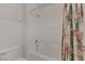 Bright bathroom featuring a clean white tiled shower and tub with a floral shower curtain at 9205 Desert Village Ave, Las Vegas, NV 89147