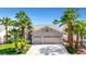 Charming single-story home with a two-car garage, landscaped front yard, and mature palm trees at 9205 Desert Village Ave, Las Vegas, NV 89147