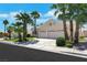 Inviting curb appeal with a well-manicured lawn and a two-car garage framed by swaying palm trees at 9205 Desert Village Ave, Las Vegas, NV 89147