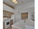 Bright kitchen featuring a breakfast bar, white appliances, and a large window at 9205 Desert Village Ave, Las Vegas, NV 89147