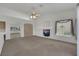 Open-concept living room featuring carpet, a ceiling fan, and decorative shelving at 9205 Desert Village Ave, Las Vegas, NV 89147