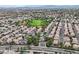 The aerial view of a residential neighborhood shows a green community park, swimming pool and desert mountains at 927 Clear Diamond Ave, Las Vegas, NV 89123