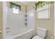 Bright bathroom featuring a tiled shower-tub combination, with natural light from the window with decorative curtain at 927 Clear Diamond Ave, Las Vegas, NV 89123