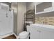 Bathroom features a shower, toilet and sink with stylish tile backsplash, offering a modern and functional space at 9840 Chief Sky St, Las Vegas, NV 89178