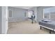 Spacious carpeted bedroom featuring gray walls, natural light from two windows, and simple furnishings at 9840 Chief Sky St, Las Vegas, NV 89178