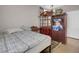 Modest bedroom featuring tile flooring and a bed with patterned comforter, plus wooden cabinet at 9840 Chief Sky St, Las Vegas, NV 89178