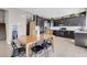 View of the open kitchen and dining area featuring dark cabinetry and stainless-steel appliances at 9840 Chief Sky St, Las Vegas, NV 89178