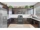 Kitchen featuring dark cabinetry, stainless steel appliances and a window over the sink at 9840 Chief Sky St, Las Vegas, NV 89178