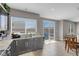 Open-concept kitchen with dark cabinetry, stainless appliances, and a sliding glass door at 9840 Chief Sky St, Las Vegas, NV 89178