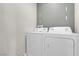 Clean laundry area featuring white washer and dryer set against neutral walls, offering convenience at 9840 Chief Sky St, Las Vegas, NV 89178