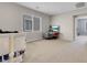 Neutral carpeted upstairs living room with large windows, offering a bright and open space at 9840 Chief Sky St, Las Vegas, NV 89178