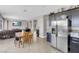 Open-concept living room and kitchen with stainless steel appliances, a TV, and a dining table at 9840 Chief Sky St, Las Vegas, NV 89178