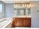 Well-lit bathroom boasts double sinks, a soaking tub, and modern fixtures at 10449 Yew Blossom Ave, Las Vegas, NV 89166