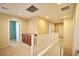 Hallway with neutral walls, carpet, white railings, and a built-in brown cabinet for storage at 10449 Yew Blossom Ave, Las Vegas, NV 89166
