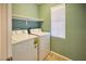 Laundry room features a washer, dryer, shelving, and a window for natural light at 10449 Yew Blossom Ave, Las Vegas, NV 89166