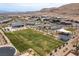Aerial view of community park featuring playground, green space, desert landscaping, and neighborhood homes at 10748 Steel Ridge Ct, Las Vegas, NV 89135