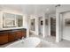 Bright bathroom featuring a soaking tub, lighted mirrors, and walk-in closet at 10748 Steel Ridge Ct, Las Vegas, NV 89135