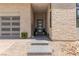 Inviting front entrance with stone accents, modern door, a brick driveway, and manicured landscaping at 10748 Steel Ridge Ct, Las Vegas, NV 89135
