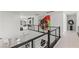 Upstairs hallway with modern railings, colorful wall art, and natural light at 10748 Steel Ridge Ct, Las Vegas, NV 89135