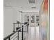 Bright hallway with modern railing, neutral tile flooring, and a large art piece adding visual interest at 10748 Steel Ridge Ct, Las Vegas, NV 89135