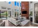 A modern living room with high ceilings, a fireplace, and sliding glass doors leading to an outdoor patio at 10748 Steel Ridge Ct, Las Vegas, NV 89135