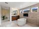 Modern bathroom with a standalone tub, wall-mounted TV, and large windows bringing in natural light at 10748 Steel Ridge Ct, Las Vegas, NV 89135
