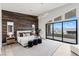 Serene main bedroom with wood accent wall, balcony access, and modern lighting at 10748 Steel Ridge Ct, Las Vegas, NV 89135