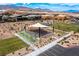 Community playground with shade and play equipment is surrounded by green space and desert landscaping at 10748 Steel Ridge Ct, Las Vegas, NV 89135