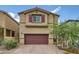 Charming home featuring a two-car garage, complemented by desert landscaping and a brick driveway at 10974 Cheshire Woods Ave, Las Vegas, NV 89166