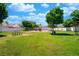 View of a community park with green grass, playground and picnic tables under a sunny blue sky with fluffy white clouds at 1436 Padre Bay Dr, Las Vegas, NV 89108