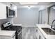 Kitchen with stainless appliances, gray walls, gray floors, white cabinets, and black hardware at 1440 Vegas Valley Dr # 3, Las Vegas, NV 89169