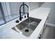 Close-up shot of a stainless steel sink and black faucet against white quartz countertops at 1440 Vegas Valley Dr # 3, Las Vegas, NV 89169