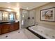 Bathroom featuring a soaking tub, glass shower, and vanity with mirror at 145 E Harmon Ave # 1120, Las Vegas, NV 89109