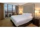 Bedroom with a large window view of the city, king bed, and nightstands at 145 E Harmon Ave # 1120, Las Vegas, NV 89109