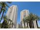 Impressive high-rise buildings with gold accents, surrounded by lush palm trees against a clear blue sky at 145 E Harmon Ave # 1120, Las Vegas, NV 89109