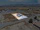 Expansive aerial view of a modern home with a fenced yard, showcasing its spacious lot and mountain views at 1500 E Laguna St, Pahrump, NV 89048