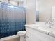 This bathroom features a shower with blue curtain, plus vanity with a white marble countertop at 1500 E Laguna St, Pahrump, NV 89048