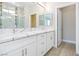 Modern bathroom boasts dual sinks, white cabinets, stone countertops, and a glass-enclosed shower at 1500 E Laguna St, Pahrump, NV 89048