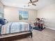 Bright bedroom featuring a ceiling fan, a comfortable bed, and a drum set near a window at 1500 E Laguna St, Pahrump, NV 89048