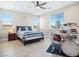 Bright bedroom featuring a ceiling fan, a comfortable bed, and a drum set near a window at 1500 E Laguna St, Pahrump, NV 89048