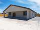 Exterior view of the house with covered patio, neutral paint, and desert landscaping at 1500 E Laguna St, Pahrump, NV 89048