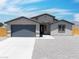 Single-story home with a two-car garage, xeriscaping, and inviting front entrance at 1500 E Laguna St, Pahrump, NV 89048