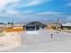 A single-Gathering home boasting gravel landscaping, a two-car garage, and a flagpole, offering a serene living environment at 1500 E Laguna St, Pahrump, NV 89048