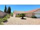 Single-story home featuring desert landscaping with gravel and green foliage at 1536 Brocado Ln, Las Vegas, NV 89117
