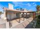 Spacious backyard patio with a covered area, pergola and lush landscaping at 1740 Leaning Pine Way, Las Vegas, NV 89128
