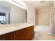 Bright bathroom with a large mirror, wooden vanity, and a shower-tub combination at 200 W Sahara Ave # 910, Las Vegas, NV 89102