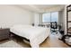 Bright, minimalist bedroom with large window, desk, hardwood floors and neutral decor at 200 W Sahara Ave # 910, Las Vegas, NV 89102