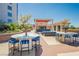 Stylish outdoor seating area with tables, stools, and a bar under a shaded structure perfect for entertaining guests at 200 W Sahara Ave # 910, Las Vegas, NV 89102