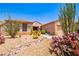 Beautiful desert landscaping with vibrant cactus and rock features enhances the home's curb appeal at 2106 King Mesa Dr, Henderson, NV 89012
