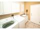 Efficient laundry room with washer, dryer, utility sink, and storage cabinets at 2106 King Mesa Dr, Henderson, NV 89012